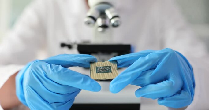 Engineer holds microprocessor in laboratory