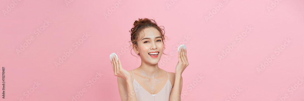 Canvas Prints Attractive beauty young asian woman clean skin with cotton pad removing make up on pink background.