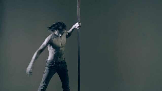 Flexible sexy body of young man. Pole dance. Sexy man exercise pole dance. Fit slim sexy man performs sensual pole dance. Go-go dancer. Strip dancer. Male athlete doing acrobatic trick on pylon.