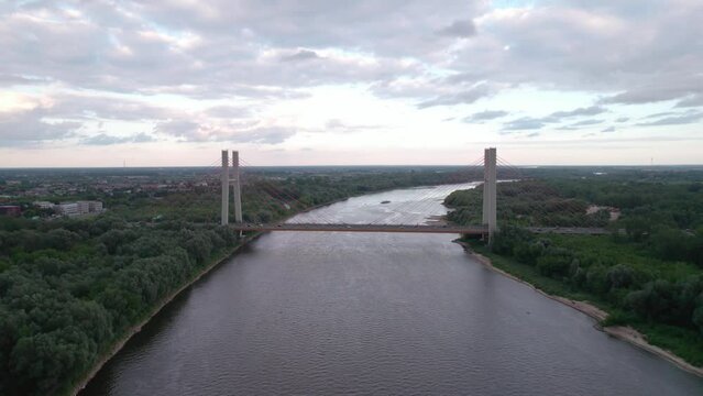 Captured by drone, the aerial view of the Vistula River in Warsaw reveals the majestic Siekierkowski Bridge in the foreground.