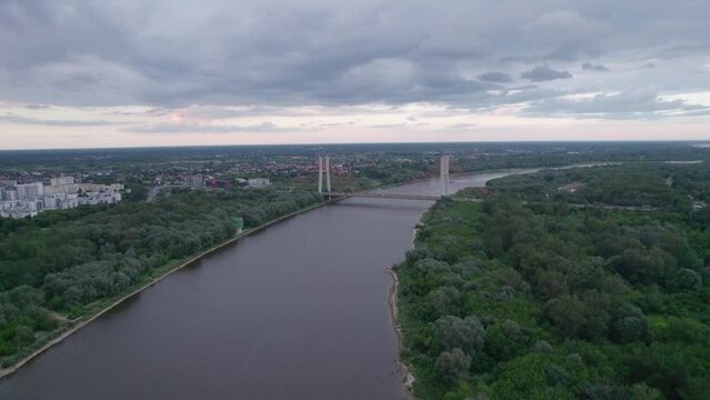 Captured by drone, the aerial view of the Vistula River in Warsaw reveals the majestic Siekierkowski Bridge in the foreground.