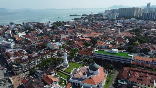 Aerial view of Masjid Kapitan Keling mosque, bottom, built in 19th century by Indian Muslim traders in George Town, Penang, Malaysia. The Malacca strait is seen in the background.