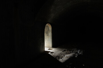 Vista degli interni totalmente oscuri di un ambiente interno ad una struttura abbandonata, con poca...