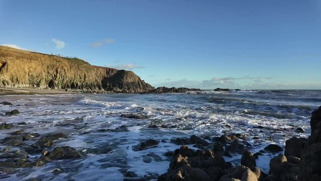 Cinematic timelapse beach incoming waves on shingle beach in winter Copper Coast Waterford Ireland