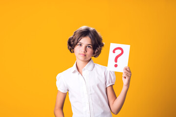 A portrain of kid girl holding question mark card. Children, idea and knowledge concept