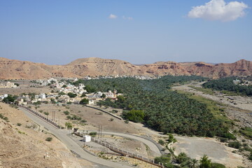 Qurayyat with lush palm trees next to Wadi Dhaiqah almost dry river bed nearby Dayqah Dam, Muscat, Oman visitor center