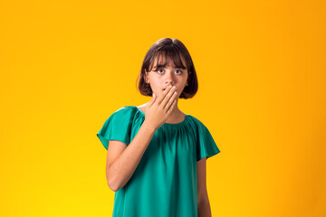 Surprised kid girl over yellow background. Astonishment concept