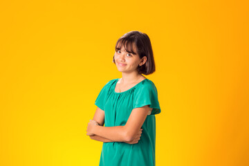 Smiling kid girl over yellow background. Emotion concept