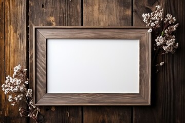 Decorated photo frame with flowers on wooden background