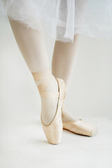 Ballerina's legs in pointe shoes on white background