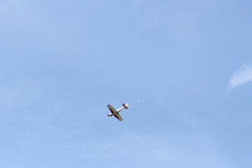 A small plane in the sky with space for text. Single plane flies lonely in the clear blue sky. Single propeller aircraft flying in heaven