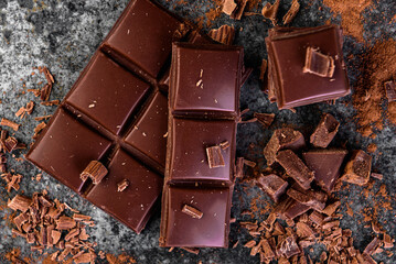 Pieces of milk chocolate on black background.
