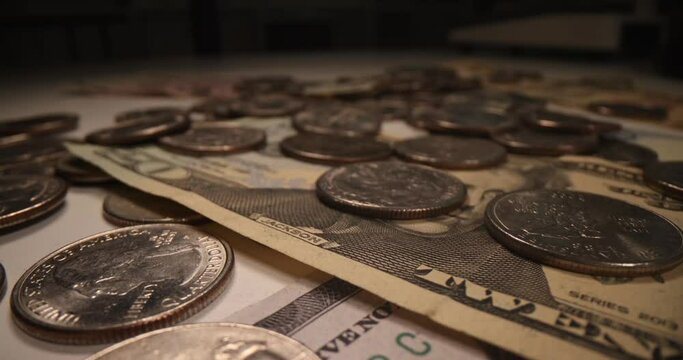 Lots of American dollars banknotes and falling coins on dark background. Hyperinflation and money printing concept