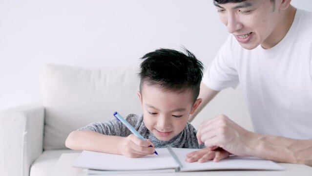 Young father checking homework helping  child  with study at home