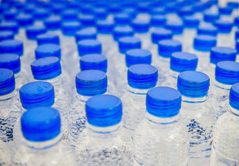 Many blue drinking water bottle caps and pure drinking water bottles in a drinking water production...