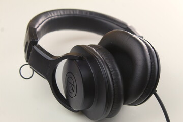 Fototapeta na wymiar Dublin, Ireland - January 4th 2024: A photo of a pair of black Audio Technica ATH-M20x studio headphones on a white desk. 