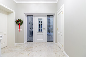 Green Christmas Wreath with red and golden balls on a black wooden front door