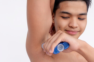 A man applies gel deodorant to his underarms after a bath. Body hygiene and odor prevention. Isolated on a white backdrop.