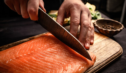 Sushi chef cuts raw salmon with knife - obrazy, fototapety, plakaty