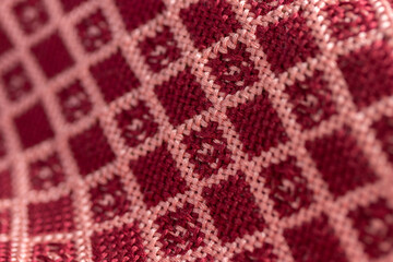 draped woven double cloth in red and pink geometric, diamond grid pattern, close up macro detail shot with shallow depth of field