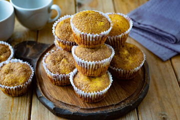 Sweet dessert: pumpkin muffins with crispy crust on a wooden board for breakfast. Close-up