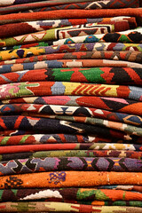 Vertical shot of a pile of colorful oriental carpets in Goreme, Cappadocia, Turkey