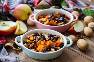 Healthy breakfast: pumpkin slices with apples, prunes and nuts in beautiful molds. Baked pumpkin with fruits and nuts. Close-up