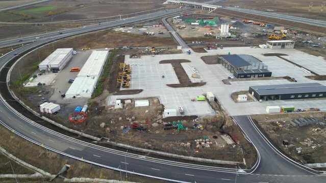 Aerial drone footage of a road construction zone hub filled with machines, equipment and future infrastructure. High angle shot of the process of highway building in Eastern Europe. Infrastructure
