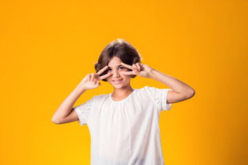 Smiling kid girl over yellow background. Emotion concept