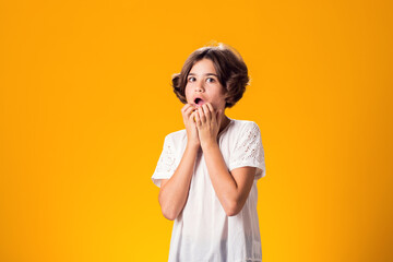 Surprised kid girl over yellow background. Astonishment concept