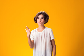 Indignant angry expressive confused kid girl over yellow background. Emotion concept