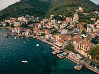 Fototapeta na wymiar Promenade with old houses and moored boats. Tivat, Montenegro. Drone