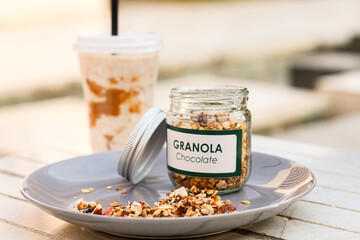 A jar of fresh and healthy granola with coffee and banana milkshake