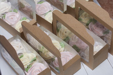 Fototapeta na wymiar Open boxes with homemade marshmallows. Zephyr flowers. Roses from zephyr. A unique gift.