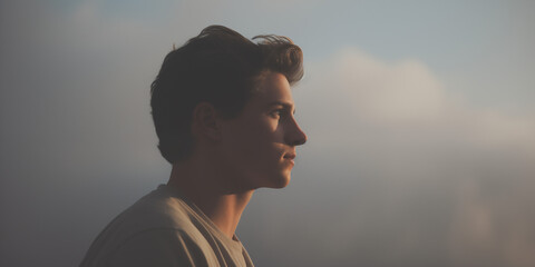 Young man with a profile view, his face calm against a backdrop of soft clouds - Powered by Adobe