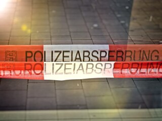 Barrier tape "Polizeiabsperrung" during a police operation in Germany.