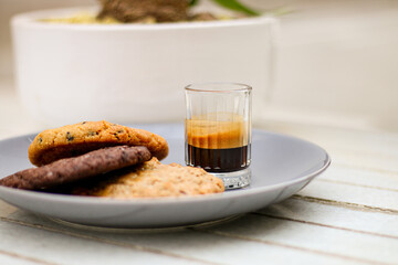 Chocolate cookie and Coffee in glass cup on rustic wooden background. Close up.