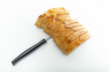 Slices of fresh bread and cutting knife on a white background, isolated. Healthy proper nutrition.