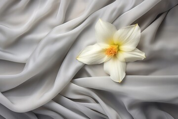  a white and yellow flower sitting on top of a white sheet covered in a white and yellow blanketed material.