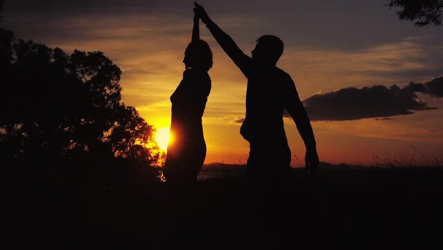 Couple dancing salsa at sunset,silhouette of couple in love at sunset against the backdrop of nature. High quality FullHD footage