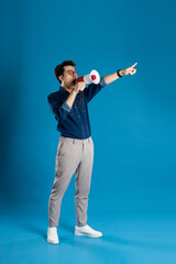 Portrait of young Asian business man posing on blue background