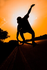 Skateboarder doing a trick on city street on sunny day. Young man in longboarding gear and sunset
