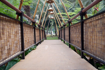 Bamboo bridge with unique traditional lights and woven bamboo as decoration in the green garden