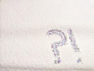 A question mark written on snow with sequins or confetti. The concept of Uncertainty of choice,...