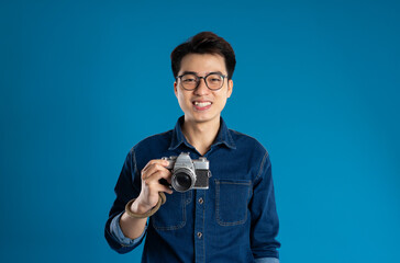 Portrait of young Asian business man posing on blue background