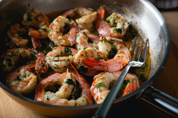 Obraz na płótnie Canvas Fried langoustines, shrimp in white wine with garlic and parsley