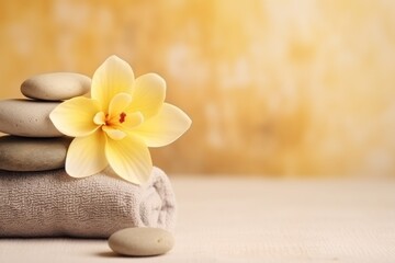  a stack of rocks with a yellow flower on top of one of the stones is placed on top of a towel.