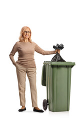 Woman throwing a plastic waste bag in a bin