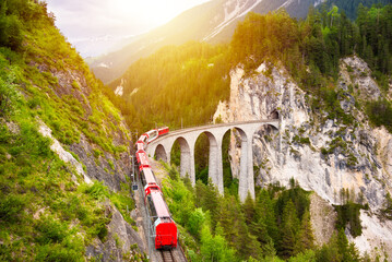 Swiss red train on viaduct in mountain, scenic ride