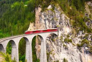 Swiss red train on viaduct in mountain, scenic ride